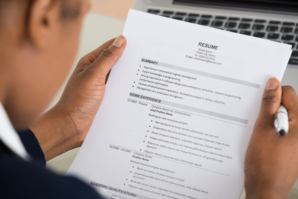 Photo looking over the shoulder of someone reading a resume.